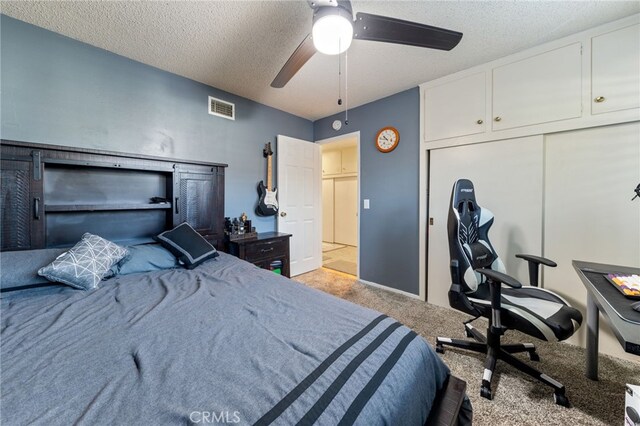 carpeted bedroom with a textured ceiling and ceiling fan