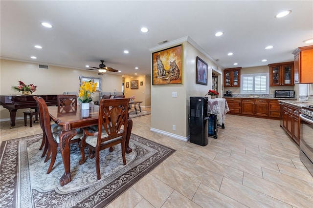 dining area with ceiling fan and ornamental molding