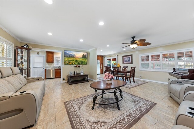 living room with ceiling fan, a wealth of natural light, and crown molding