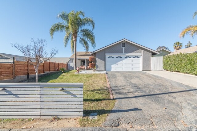 single story home with a garage and a front lawn