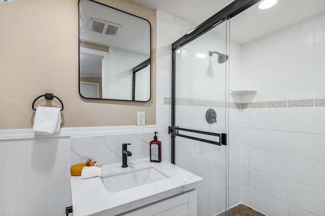 bathroom with a shower with door and vanity