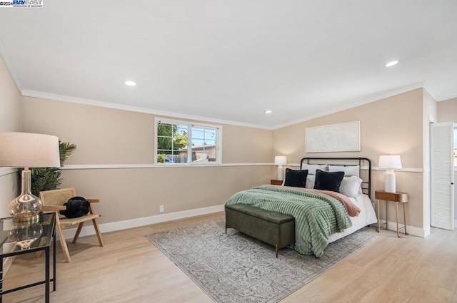 bedroom with ornamental molding and light hardwood / wood-style flooring