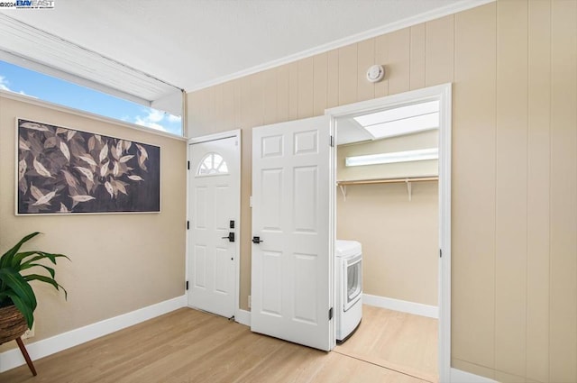 foyer entrance featuring ornamental molding, washer / clothes dryer, and light hardwood / wood-style floors