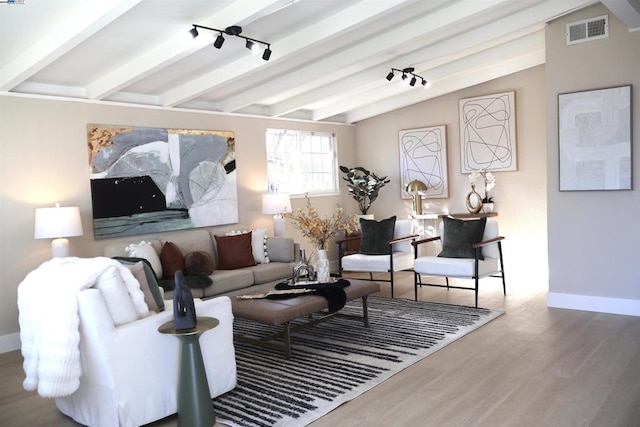 living room featuring lofted ceiling with beams and hardwood / wood-style floors