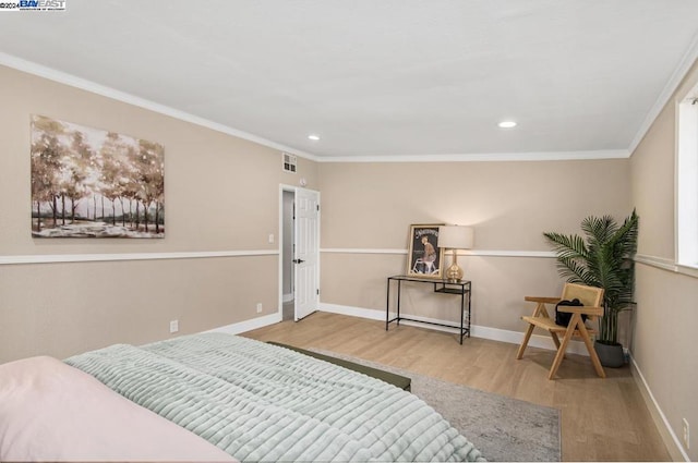 bedroom with light wood-type flooring and crown molding