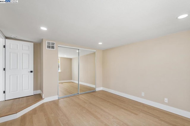 unfurnished bedroom with a closet and hardwood / wood-style floors