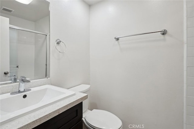 bathroom with vanity, walk in shower, and toilet