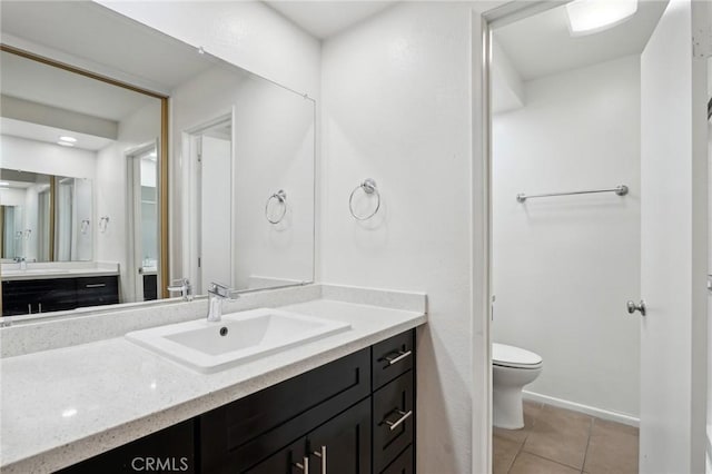 bathroom featuring vanity, toilet, and tile patterned flooring