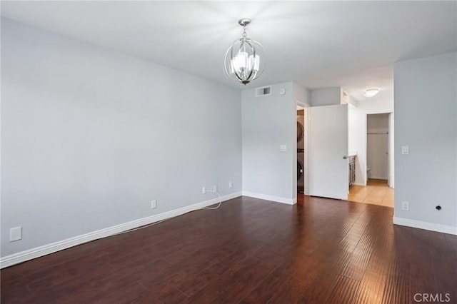 spare room with hardwood / wood-style flooring and a notable chandelier