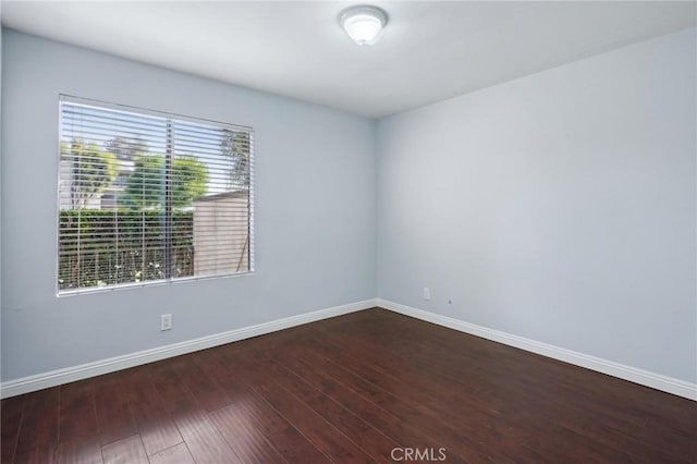 empty room with hardwood / wood-style flooring and a wealth of natural light