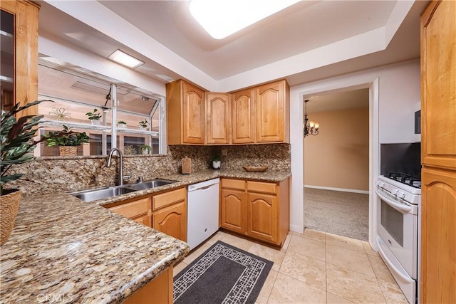 kitchen featuring white appliances, tasteful backsplash, sink, light stone counters, and light colored carpet