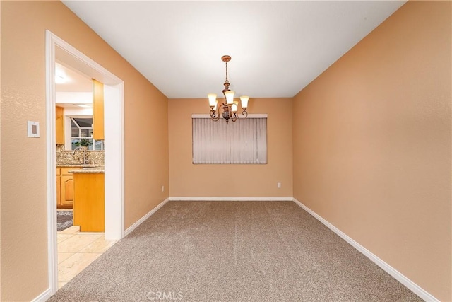 empty room with light carpet, sink, and an inviting chandelier