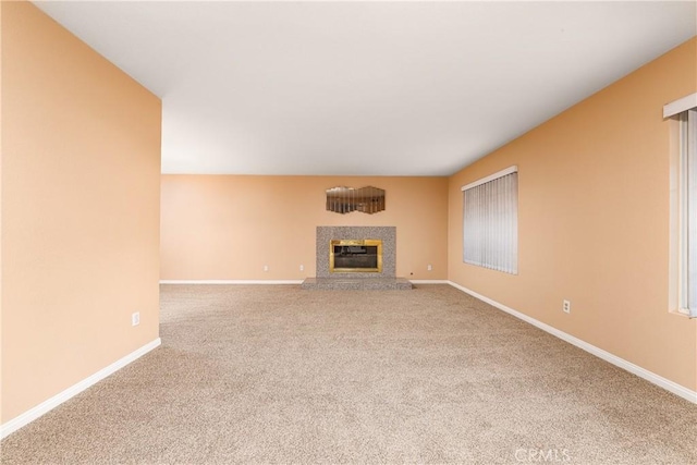 unfurnished living room with carpet and a fireplace