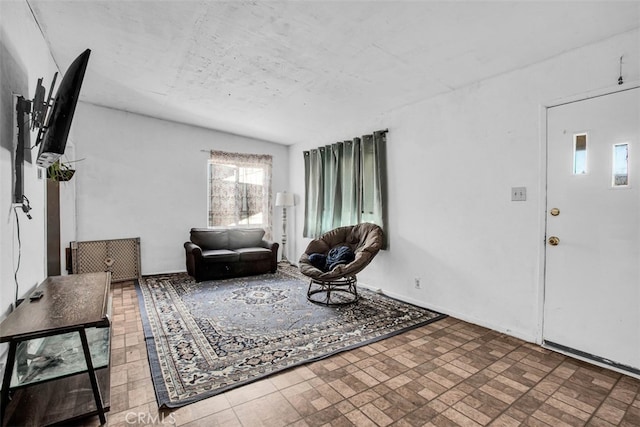 living room featuring a textured ceiling and vaulted ceiling