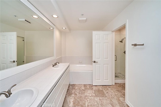 bathroom with vanity and independent shower and bath