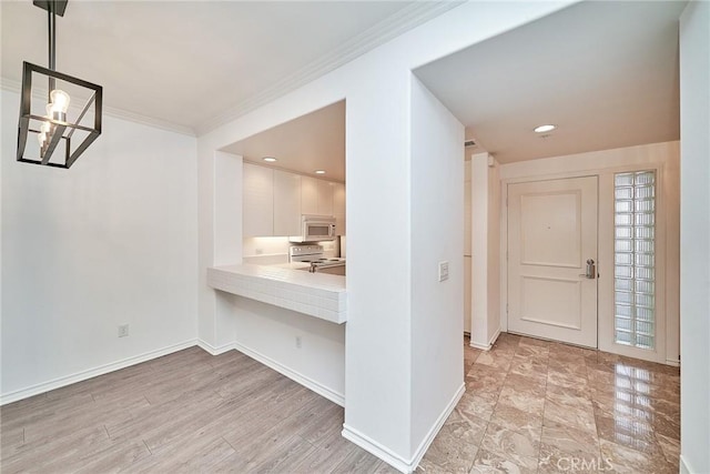 entryway with a notable chandelier and ornamental molding