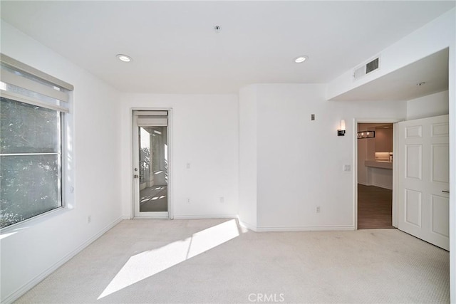 empty room featuring light carpet and a healthy amount of sunlight