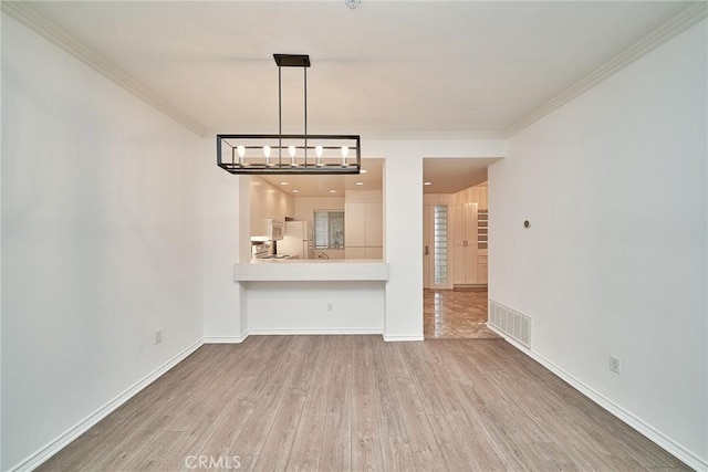 unfurnished living room with crown molding and hardwood / wood-style flooring