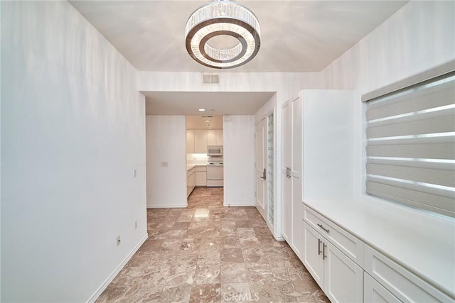 corridor with an inviting chandelier