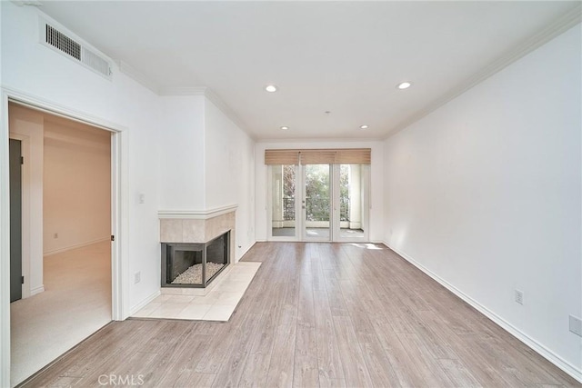 unfurnished living room featuring crown molding, a multi sided fireplace, and light hardwood / wood-style floors