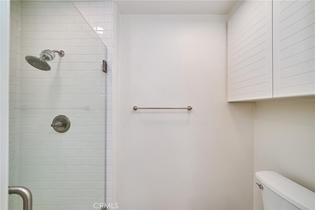 bathroom with toilet and a shower with door