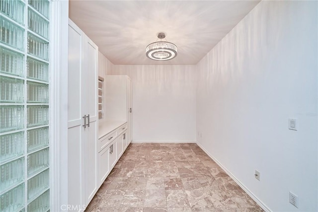 walk in closet with a chandelier