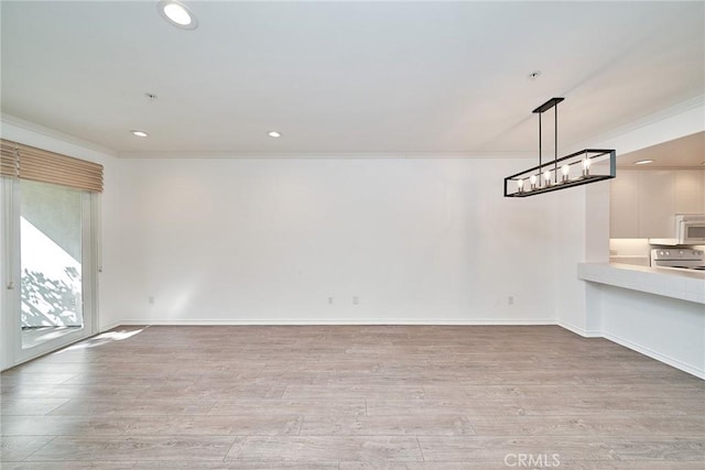 empty room with ornamental molding and light hardwood / wood-style floors