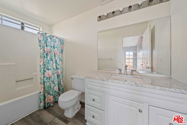 full bathroom featuring hardwood / wood-style floors, vanity, shower / bathtub combination with curtain, and a healthy amount of sunlight