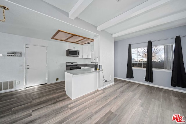 kitchen with white cabinetry, hardwood / wood-style flooring, kitchen peninsula, stainless steel appliances, and beamed ceiling