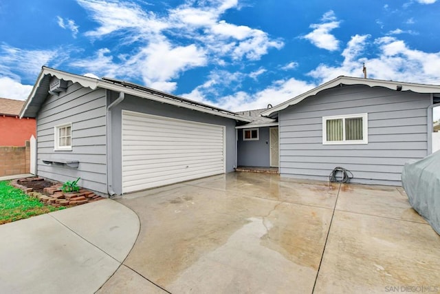 view of front of home with a garage and a patio