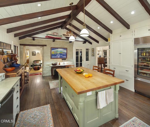 kitchen with a center island, wooden counters, hanging light fixtures, lofted ceiling with beams, and green cabinetry