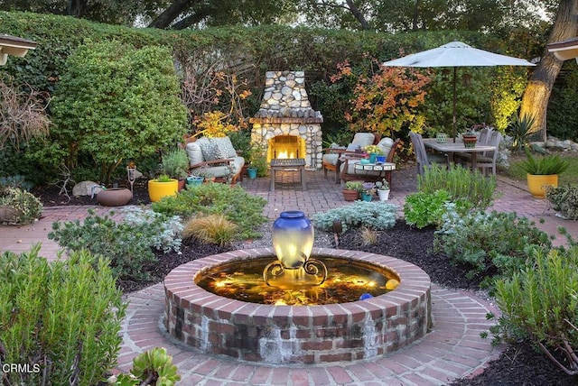 view of yard featuring an outdoor living space with a fireplace and a patio