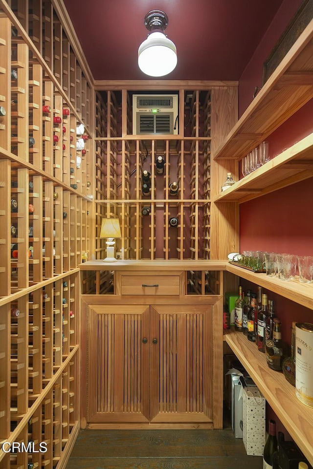 wine area with dark wood-type flooring and a wall mounted air conditioner