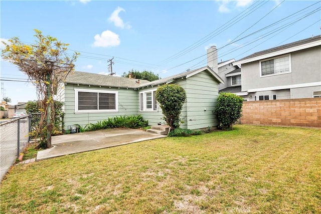 back of house with a patio area and a yard