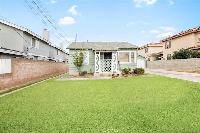 view of front of house with a front lawn and an outbuilding