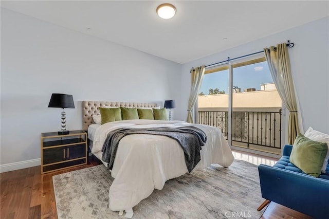 bedroom with access to exterior and hardwood / wood-style flooring