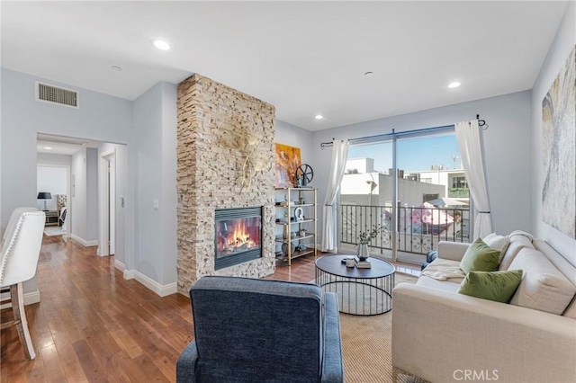 living room with wood-type flooring and a fireplace