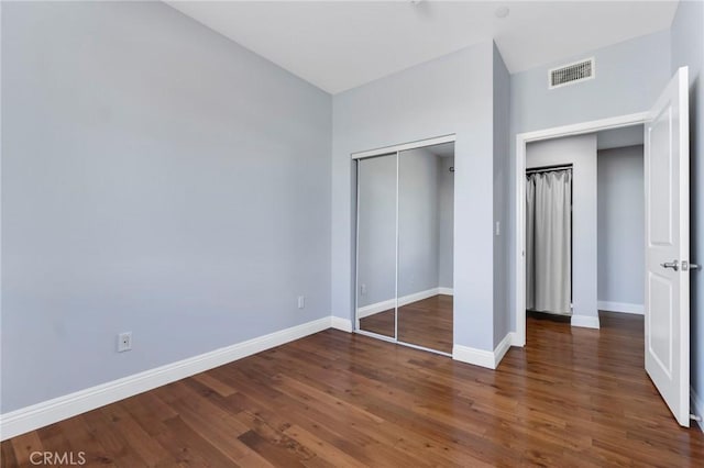 unfurnished bedroom featuring a closet and dark hardwood / wood-style floors