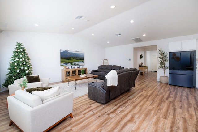 living room featuring vaulted ceiling and light hardwood / wood-style floors