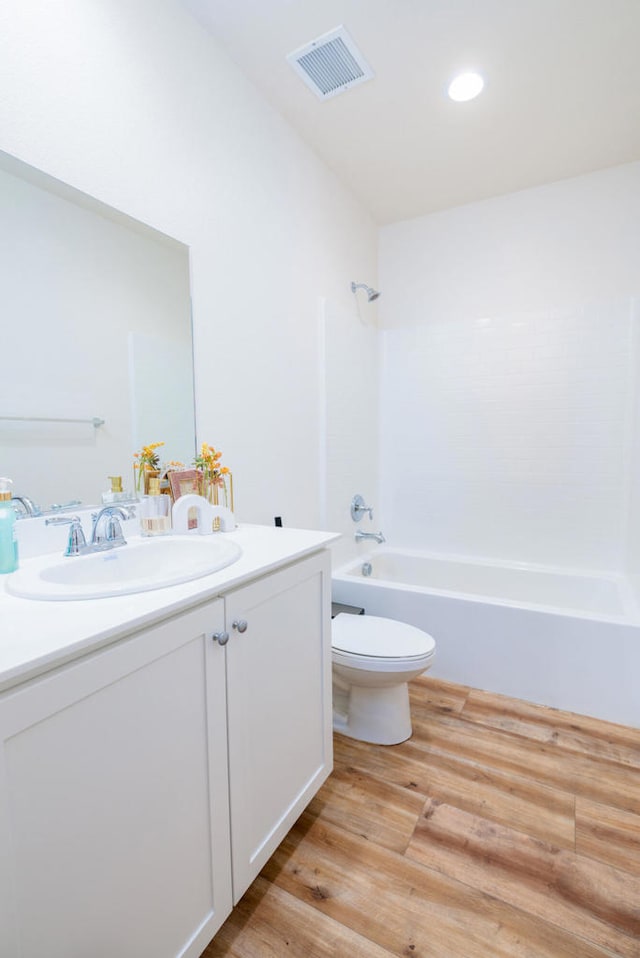 full bathroom featuring toilet,  shower combination, hardwood / wood-style flooring, and vanity