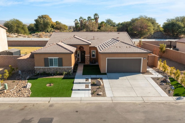 ranch-style home featuring a garage and a front lawn