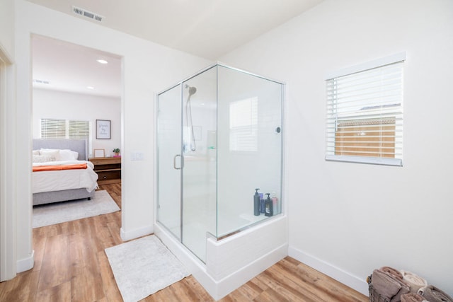 bathroom featuring a shower with door and hardwood / wood-style flooring