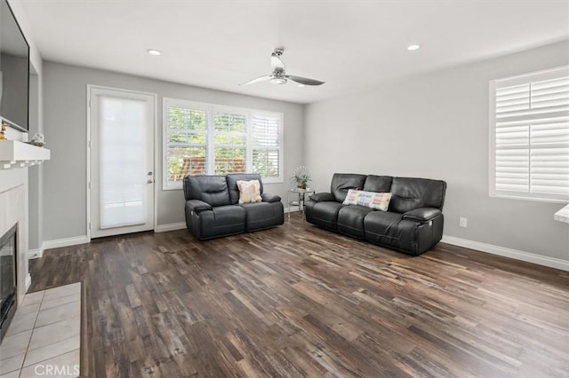 living room with ceiling fan, a fireplace, and hardwood / wood-style flooring