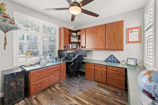 office area with ceiling fan, dark hardwood / wood-style flooring, and built in desk