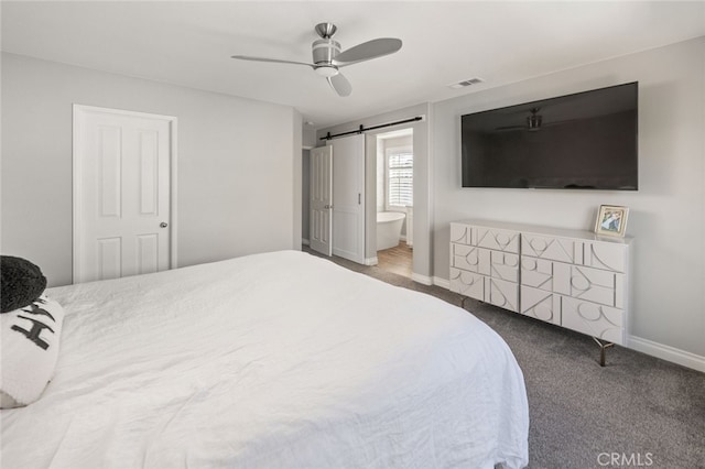 carpeted bedroom with ceiling fan, connected bathroom, a closet, and a barn door