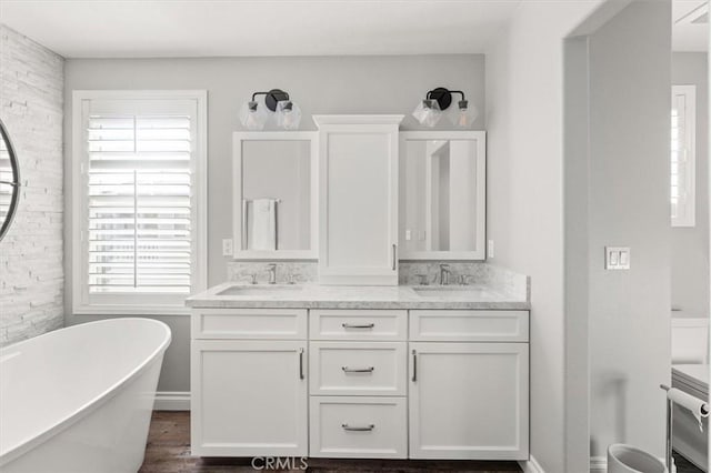 bathroom featuring a wealth of natural light, a tub to relax in, hardwood / wood-style floors, and vanity