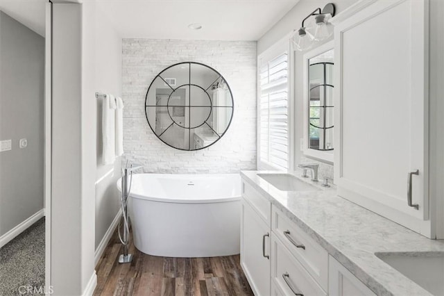 bathroom with a tub to relax in, hardwood / wood-style flooring, and vanity