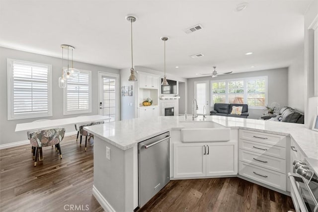 kitchen with pendant lighting, sink, white cabinetry, and appliances with stainless steel finishes