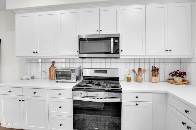 kitchen with tasteful backsplash, stainless steel appliances, and white cabinetry