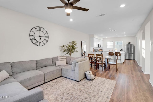 living room featuring ceiling fan and light hardwood / wood-style flooring